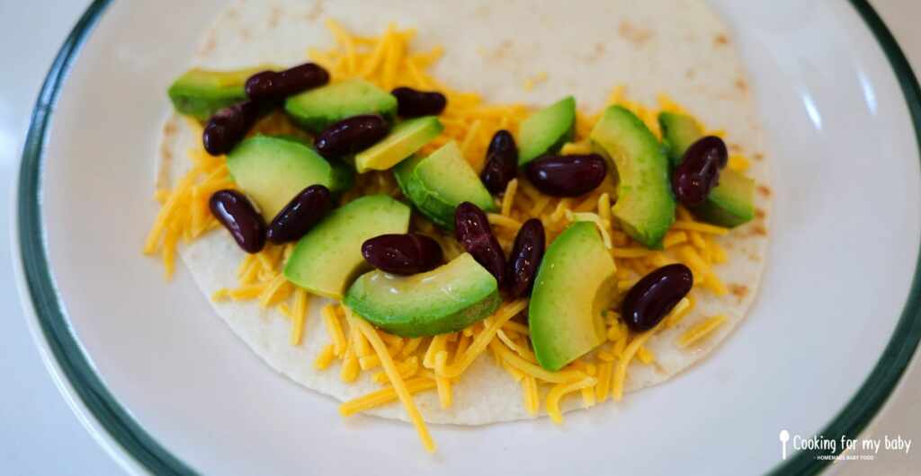 Avocado, red kidney beans, and cheddar in a tortilla for baby quesadillas