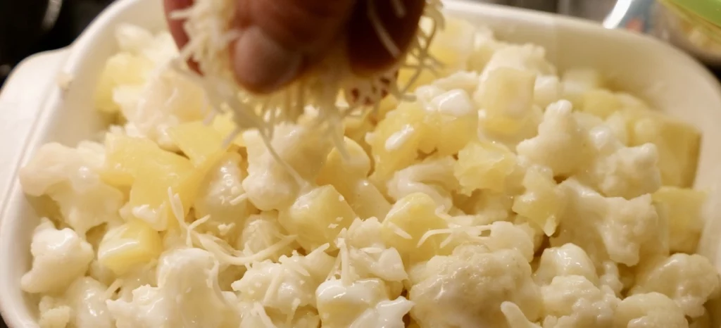 Sprinkling Gruyère over the gratin